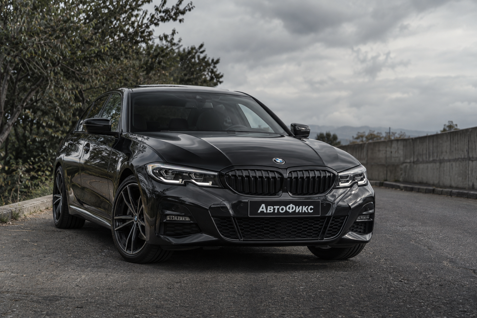 Чёрный BMW с надписью «АвтоФикс» на номерной табличке